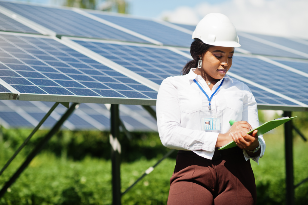 A contractor holding a clipboard in front of a solar array.